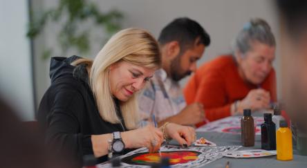 A group of multi-racial people with different ages are joining an art painting therapy session class.