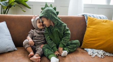 Kids in costumes at home celebrating Halloween.