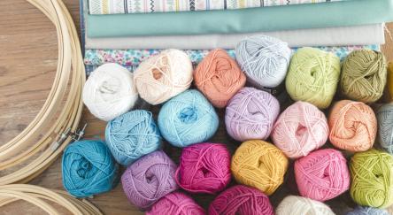 Punch needle or embroidery wool with different fabrics and hoops. Different colour and size yarn.