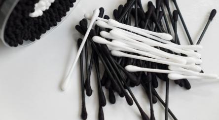 A pile of black and white cotton swabs.