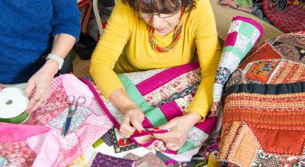 Two women working on their patchwork in a workshop.