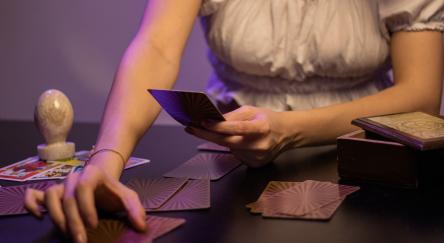 Fortune teller woman with tarot cards on the table.