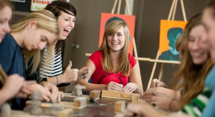 A group of high school students sculpting clay in art class.