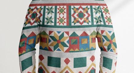 A person is wearing a Christmas sweater indoors. The sweater features distinct patterns and has long sleeves.