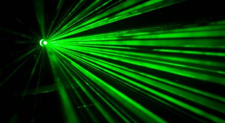 Striking green laser beams radiate from a single point of origin, a laser gun, on the left. 