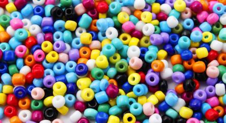 Background with many colored pony beads used to make necklaces and bracelets.