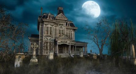An old abandoned Victorian mansion house with tomb stones in the garden under a moonlit sky.