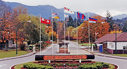 Sign at the forefront of flags signaling the Main Gate of Canadian Forces Base Chilliwack