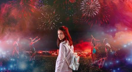 Girl with backpack, and other kids overlook city with fireworks - fantasy theme.