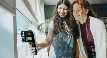 Two teenage girls use a Thermal Leak Detector from the FVRL Playground collection.