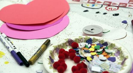 Paper hearts and craft supplies on a table.