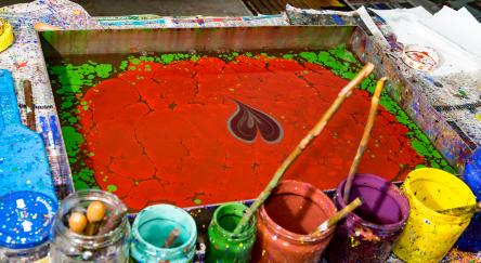 Paper marbling technique shown with paint heart floating on water.