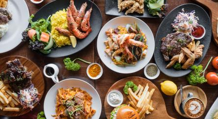 Top looking down at restaurant food spread on table.
