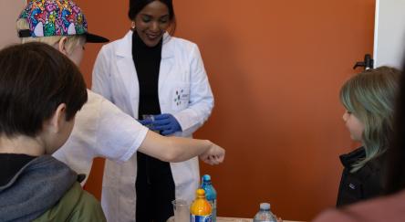 Dr Drummond running an experiment with junior scientists