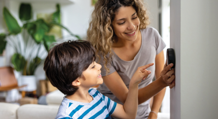 Picture of adult and child looking at thermostat 