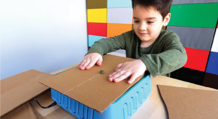 Photo of kid sawing cardboard on the ChompSaw