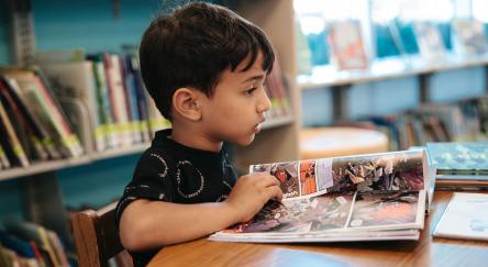 A young boy reads a graphic novel at FVRL's Terry Fox Library.