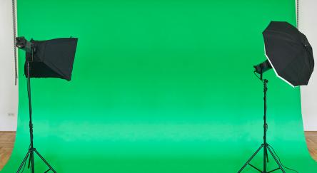 Empty green studio backdrop with softboxes.