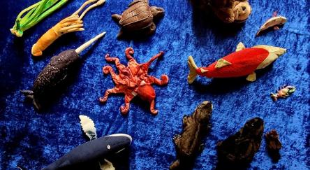 Collection of ocean-themed puppets and figurines on blue background