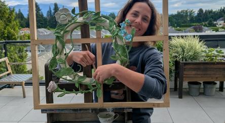 person standing behind window frame with wreath