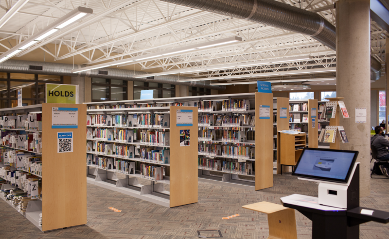 A view inside Abbotsford Community Library, featuring an extensive array of books lining the shelves for visitors to explore.