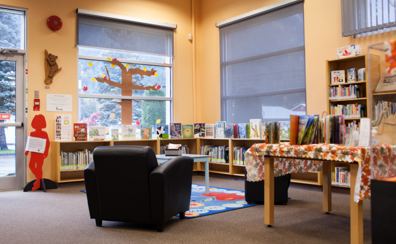 Interior view of Hope Library's children's area, showcasing a large table with several chairs arranged around it.