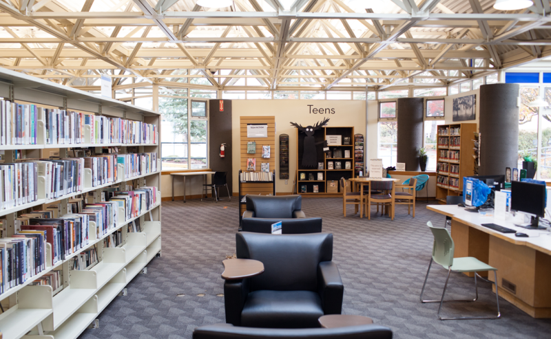 Interior view of Chilliwack Library filled with numerous books on shelves, creating a cozy reading atmosphere.