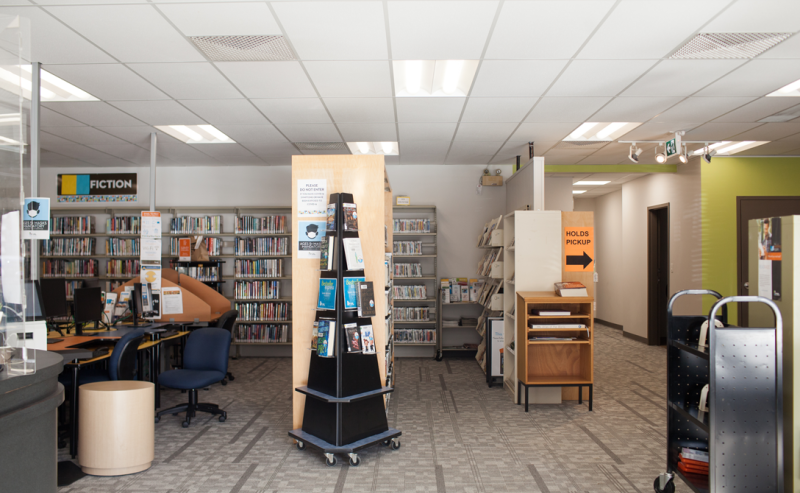 A cozy interior of Brookswood Library showcasing rows of bookshelves packed with books.