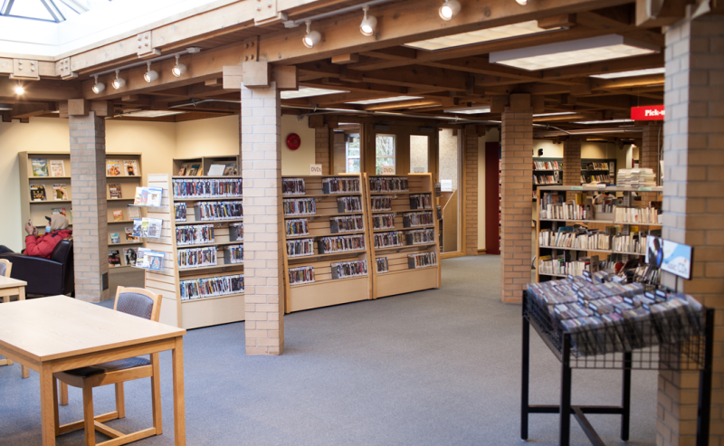 Interior view of Ladner Pioneer Library showcasing a large table with chairs in a bright, open room.