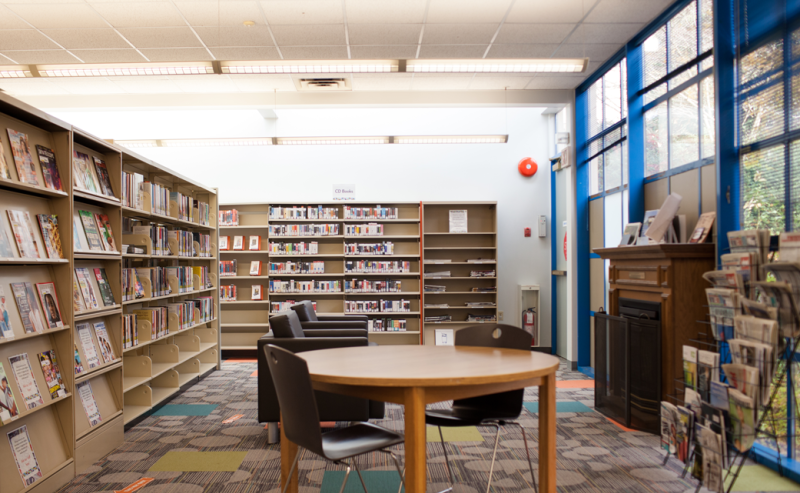 Inside George Mackie Library, numerous books line the shelves, offering a warm and welcoming space for readers.