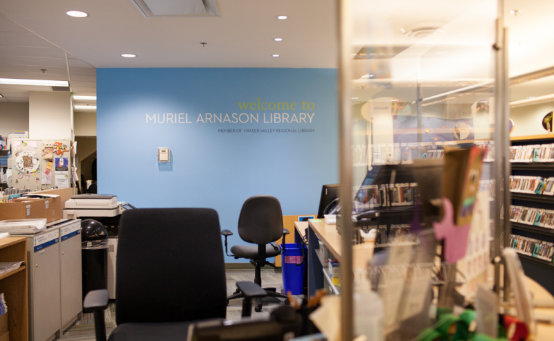 A couple of chairs and computers located at the information desk in Muriel Arnason Library's interior.