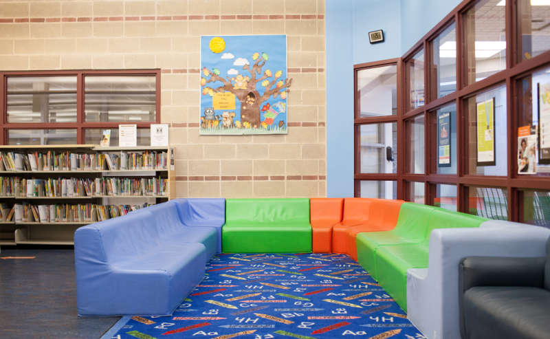 Spacious blue couch located in Dean Drysdale Library, offering a comfortable spot for relaxation and study.