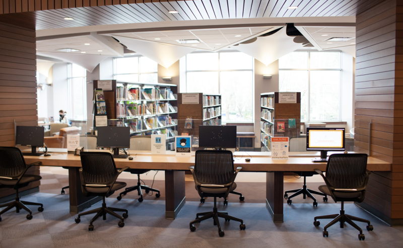  Interior view of Pitt Meadows Public Library featuring a long table with public computers and chairs, perfect for individual work.