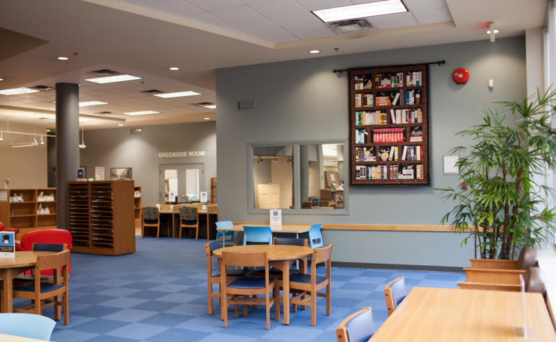 Interior view of Maple Ridge Public Library featuring a dark blue and light blue checkered floor, enhancing the space's charm.