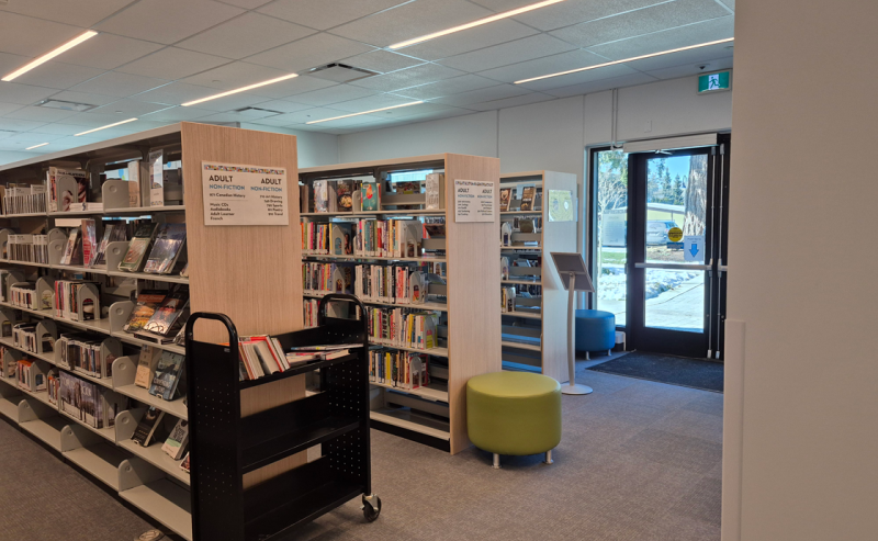 Fort Langley Library interior with organized bookshelves and a cart for convenient book retrieval.
