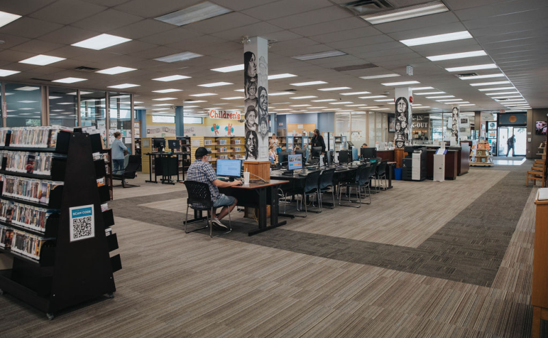 Inside Mission Library, individuals are engaged at desks and computers, immersed in their studies and research.