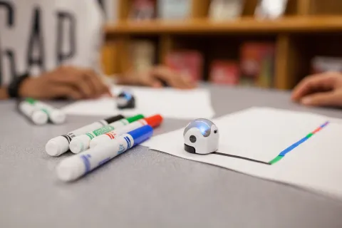 Robotic balls - Ozobots - sit on a table with marker and paper.