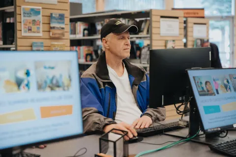 A library customer browses the FVRL online catalogue at a computer terminal at Hope Library.