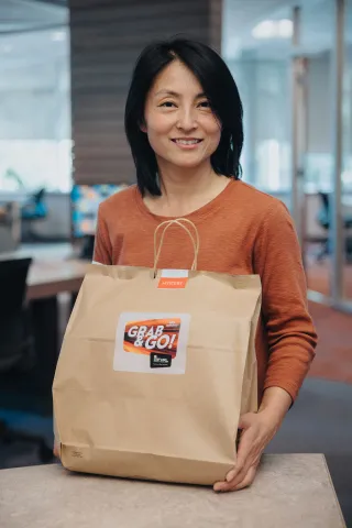 A staff member at Pitt Meadows Public Library holds an FVRL Grab & Go bag.