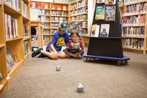 Young boys at Yarrow Library try out Sphero robots from the FVRL Playground collection.