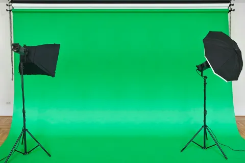 Empty green studio backdrop with softboxes.