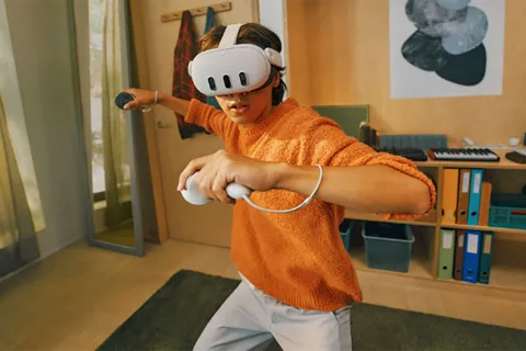 Teen using mixed reality VR headset with controllers.