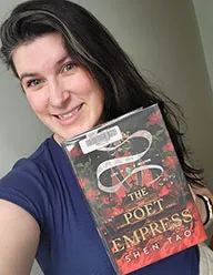 FVRL Reading Adviser Kelli poses with a book in her hand.