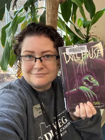 FVRL Reading Adviser Sally poses with the book The Doll House by D.W. Gillespie.
