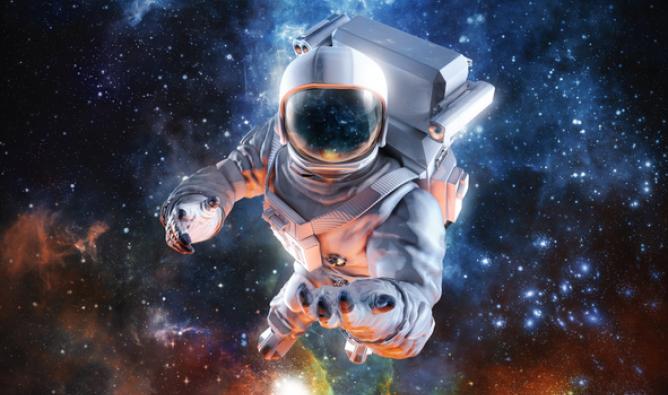 An astronaut in a space suit floats in space, with bright galaxies visible in the background.