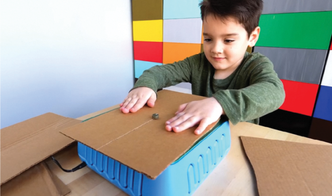 Photo of kid sawing cardboard on the ChompSaw