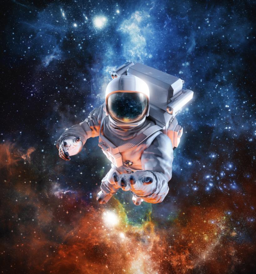 An astronaut in a space suit floats in space, with bright galaxies visible in the background.
